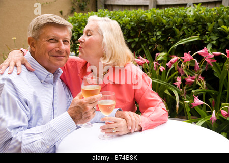 Seitenansicht des senior paar sitzt am Tisch trinken Wein im Garten Stockfoto