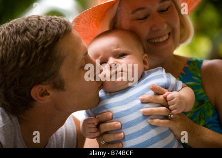 Nahaufnahme der Großmutter Holding Enkel während Vater einen Kuss gibt Stockfoto