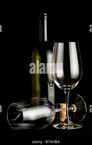 Zwei leere Weißweingläser und eine grüne Weinflasche auf schwarz mit Kork Stockfoto