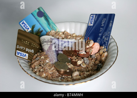 eine Schüssel mit Credit Crunch Kreditkarten Banknoten und Münzen, die Typisierung einer kommerzielles Frühstück ein Banker oder Finanzier hätte Stockfoto