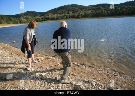 Frau und ihren Vater skimming Steinen am Lac de St Ferreol Frankreich Stockfoto