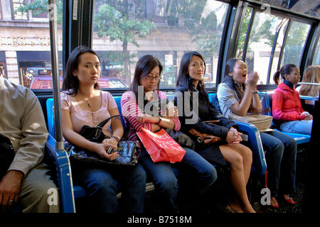 Asiatische und afrikanische amerikanische Frauen fahren Bus ein Fifth Avenue in New York City Hinweis Frau Niesen auf der rechten Seite Stockfoto