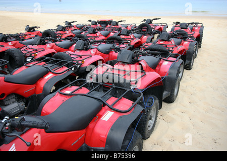 EINE GRUPPE VON ROTEN QUADS, AUFGEREIHT AUF EINEM STRAND UND GEPARKTEN IN ENGER FORMATION HORIZONTALE BDB11393 Stockfoto