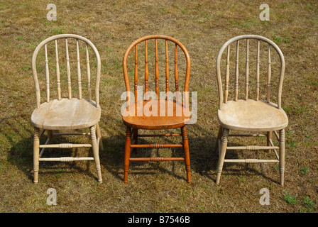 Gruppe von drei Bugholzstühle, eins poliert und zwei ungeschliffen, stehend auf dem Rasen Stockfoto