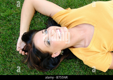 Junge Frau, die Verlegung auf dem Rasen, Regina, Saskatchewan Stockfoto