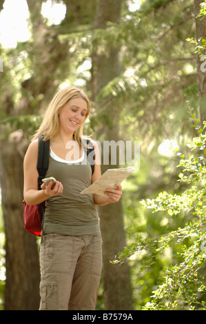 Junge Frau mit Gps-Typ-Gerät und Karte in Wäldern, Regina, Saskatchewan Stockfoto