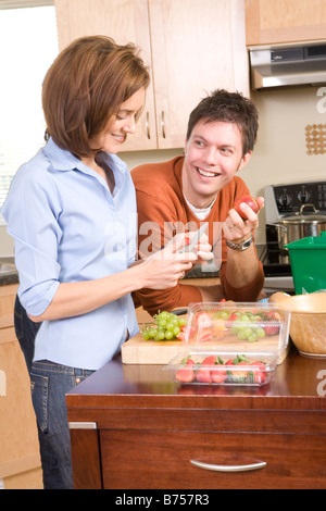 Frau, Schneiden von Obst, Mann neben Küche Kompost, Winnipeg, Kanada Stockfoto
