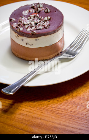 Schokoladen-Käsekuchen Dessert auf einem weißen Teller geschichtet Stockfoto