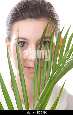 Gesicht einer jungen Frau, die hinter einem Blatt, Winnipeg, Manitoba Stockfoto