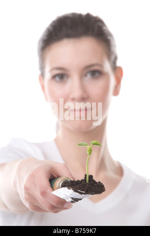 Gesicht einer jungen Frau mit einer Kelle und kleine Pflanze, Winnipeg, Manitoba Stockfoto