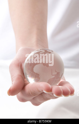 Weibliche Hand hält einen Globus, Winnipeg, Manitoba Stockfoto