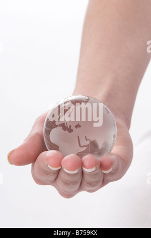 Weibliche Hand hält einen Globus, Winnipeg, Manitoba Stockfoto