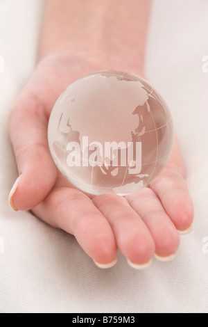 Weibliche Hand hält einen Globus, Winnipeg, Manitoba Stockfoto