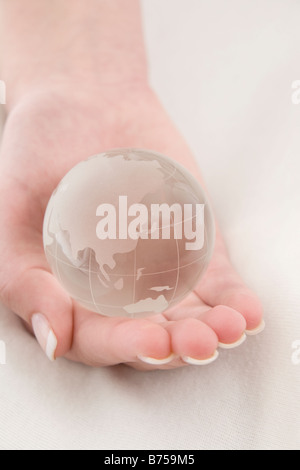 Weibliche Hand hält einen Globus, Winnipeg, Manitoba Stockfoto