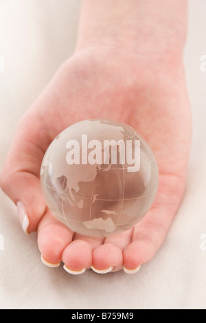 Weibliche Hand hält einen Globus, Winnipeg, Manitoba Stockfoto
