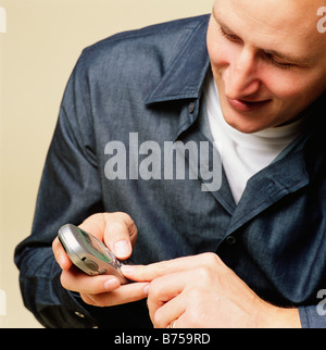 Lächelnder Mann mit Handy telefonieren, SMS senden Stockfoto