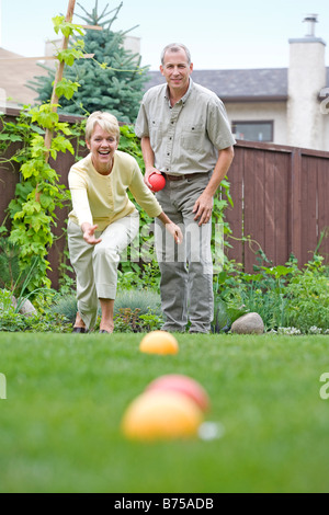 Älteres Paar spielt Bocciakugel im Hinterhof, Winnipeg, Manitoba, Kanada Stockfoto