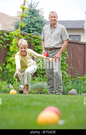 Älteres Paar spielt Bocciakugel im Hinterhof, Winnipeg, Manitoba, Kanada Stockfoto