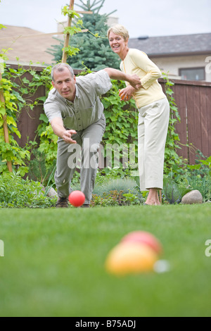 Älteres Paar spielt Bocciakugel im Hinterhof, Winnipeg, Manitoba, Kanada Stockfoto