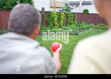 Älteres Paar spielt Bocciakugel im Hinterhof, Winnipeg, Manitoba, Kanada Stockfoto