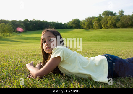 Achtjähriges Mädchen Festlegung auf dem Rasen im Park, Winnipeg, Kanada Stockfoto