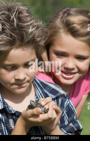 Acht Jahre alter Junge und sechs Jahre alten Mädchen mit Schildkröte, Winnipeg, Manitoba, Kanada Stockfoto