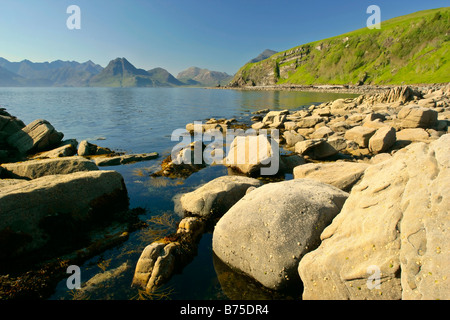 Sonnenuntergang am Strand in der Nähe von Elgol mit Findlingen im Vordergrund und zerklüfteten Cuillin Berge im Hintergrund Elgol Isle Scotland UK Stockfoto