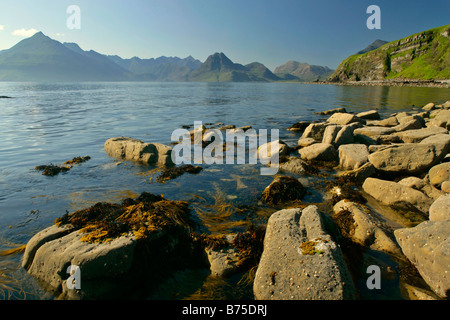 Sonnenuntergang am Strand in der Nähe von Elgol mit Findlingen im Vordergrund und zerklüfteten Cuillin Berge im Hintergrund Elgol Isle Scotland UK Stockfoto