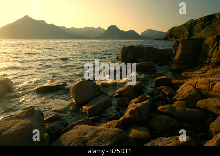 Sonnenuntergang am Strand in der Nähe von Elgol mit Findlingen im Vordergrund und zerklüfteten Cuillin Berge im Hintergrund Elgol Isle Scotland UK Stockfoto