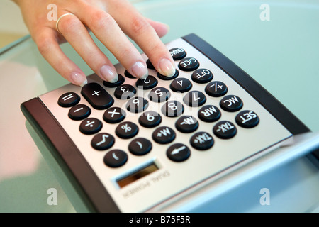 Frau Mit Einem Taschenrechner, Frau Verwendung eines Taschenrechners Stockfoto