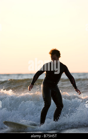 Surfertyp balancieren auf einer Welle im Lake Michigan Stockfoto