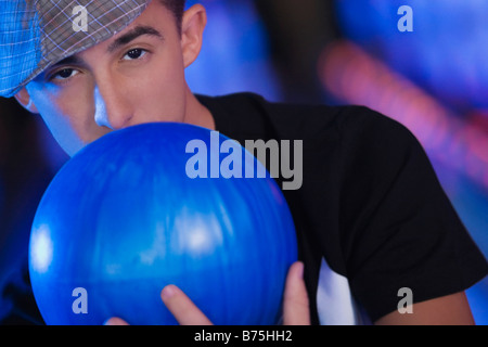 Porträt eines jungen Mannes hält eine Bowling-Kugel Stockfoto