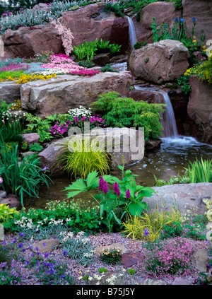 Bunte alpine bepflanzten Steingarten und Wasserfall Stockfoto