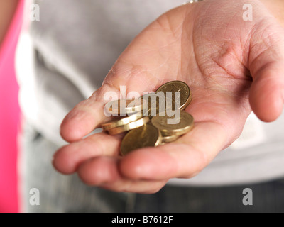 Junge Person, die Hand mit Pfund-Münzen in palm Stockfoto