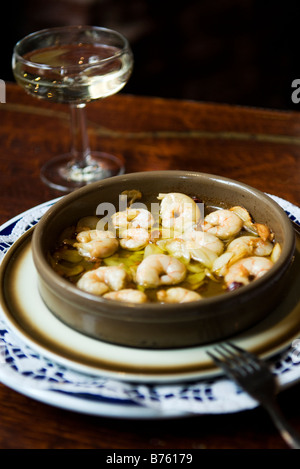 Gambas al Ajilo, Garnelen gebraten in Knoblauch und Öl und einem Glas Cava spanischer Sekt in spanischen Tapas-Bar Stockfoto