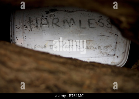 Geocache-Schatzkiste gefunden in der Landschaft unter einem Protokoll-Stapel Stockfoto