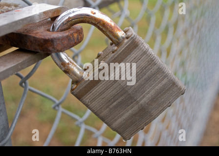 Rostige Vorhängeschloß sichern Kette Link Zaun Tor Stockfoto