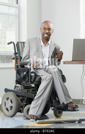 Geschäftsmann mit zerebraler Lähmung arbeiten auf einem Computer mit seinem Fuß Stockfoto