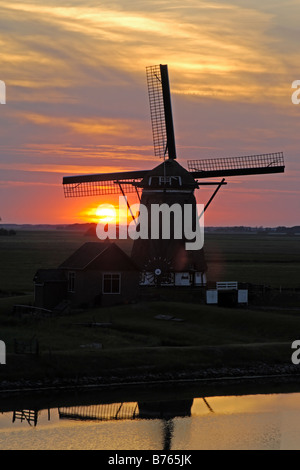 holländische Windmühle roten Sonnenuntergang Hintergrundbeleuchtung Texel Insel Nord Holland Europa Nachleuchten Stockfoto