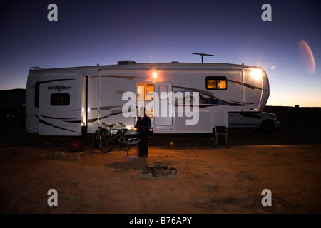 Frau Kochen bei Nacht am Grill draußen ein fünftes Rad recreational vehicle am Lone Rock Beach Primitive Campground am Lake Powell, Arizona, United States lagerten Stockfoto