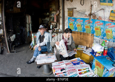 Lokale chinesische Zeitungskiosk mit neuesten chinesischen Schlagzeilen zwei ältere Männer sind das neue China kürzlich Profilverbindung Einschränkungen verkaufen Stockfoto