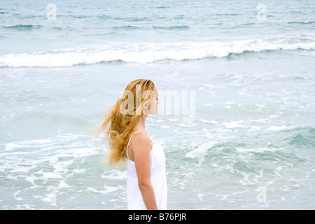 Junge Frau Strand entlang spazieren Stockfoto