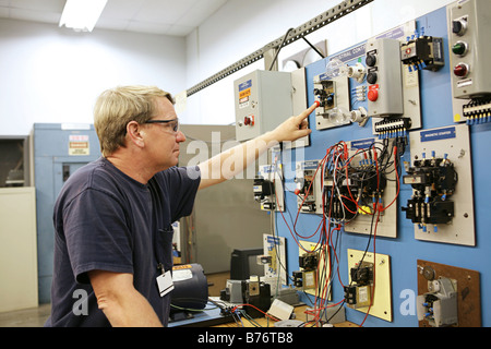 Eine elektrische Lehrer arbeiten auf eine industrielle motor Control Centers in einem Klassenzimmer Stockfoto