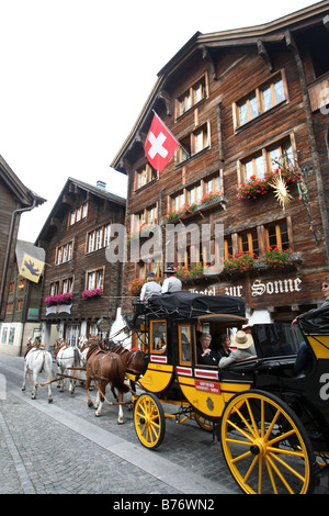 Pferdekutsche Kutsche vor dem Hotel Sonne in der Mitte der Stadt von Andermatt in der Schweiz. Stockfoto