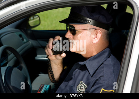 Polizisten im Streifenwagen reden auf seinem Radio Detailansicht Stockfoto