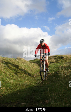 Junge weibliche Mountainbiker Abstieg in langen Dale in Derbyshire Dales des Peak District Stockfoto