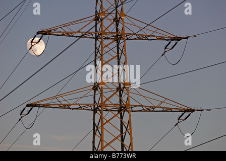 Hochspannungs-Strommast mit Vollmond über Bergen, Leichlingen, Nordrhein-Westfalen, Deutschland. Stockfoto