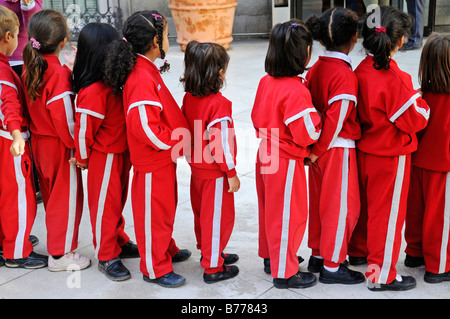 Schülerinnen und Schüler tragen rote Ausbildung Uniformen, warten in einer Reihe, Schlange, Madrid, Spanien, Europa Stockfoto