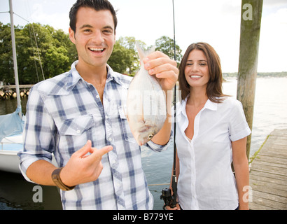 Porträt des Paares hält frisch gefangenen Fisch Stockfoto