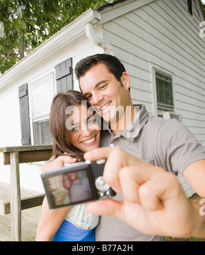 Paar unter Selbstporträt vor dem Haus Stockfoto